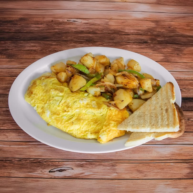 A breakfast plate with a fluffy omelet, seasoned home fries with peppers and onions, and two slices of toast.